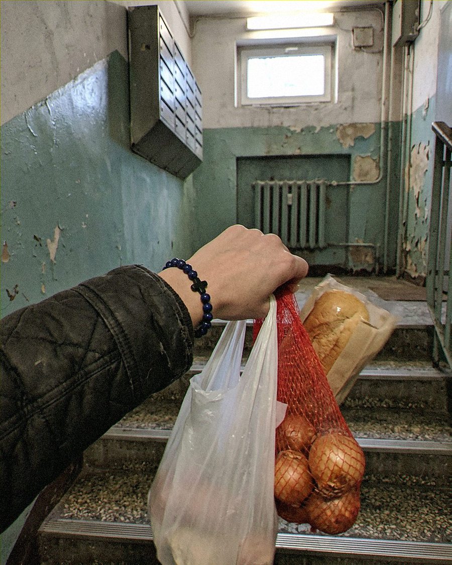 Dłoń z siatką zakupów, na nadgarstku bransoletka z lapis lazuli